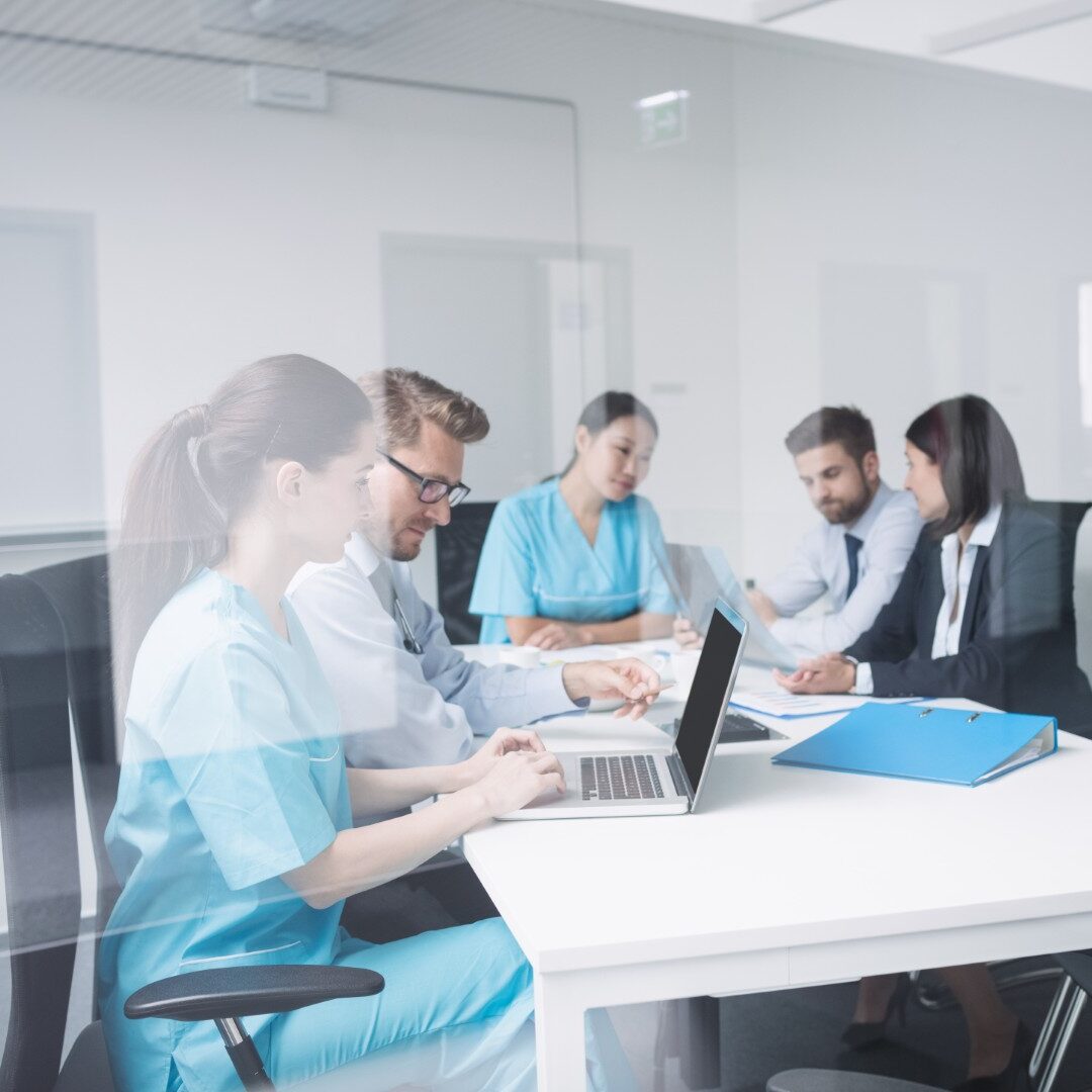 Doctors discussing over laptop in meeting at conference room